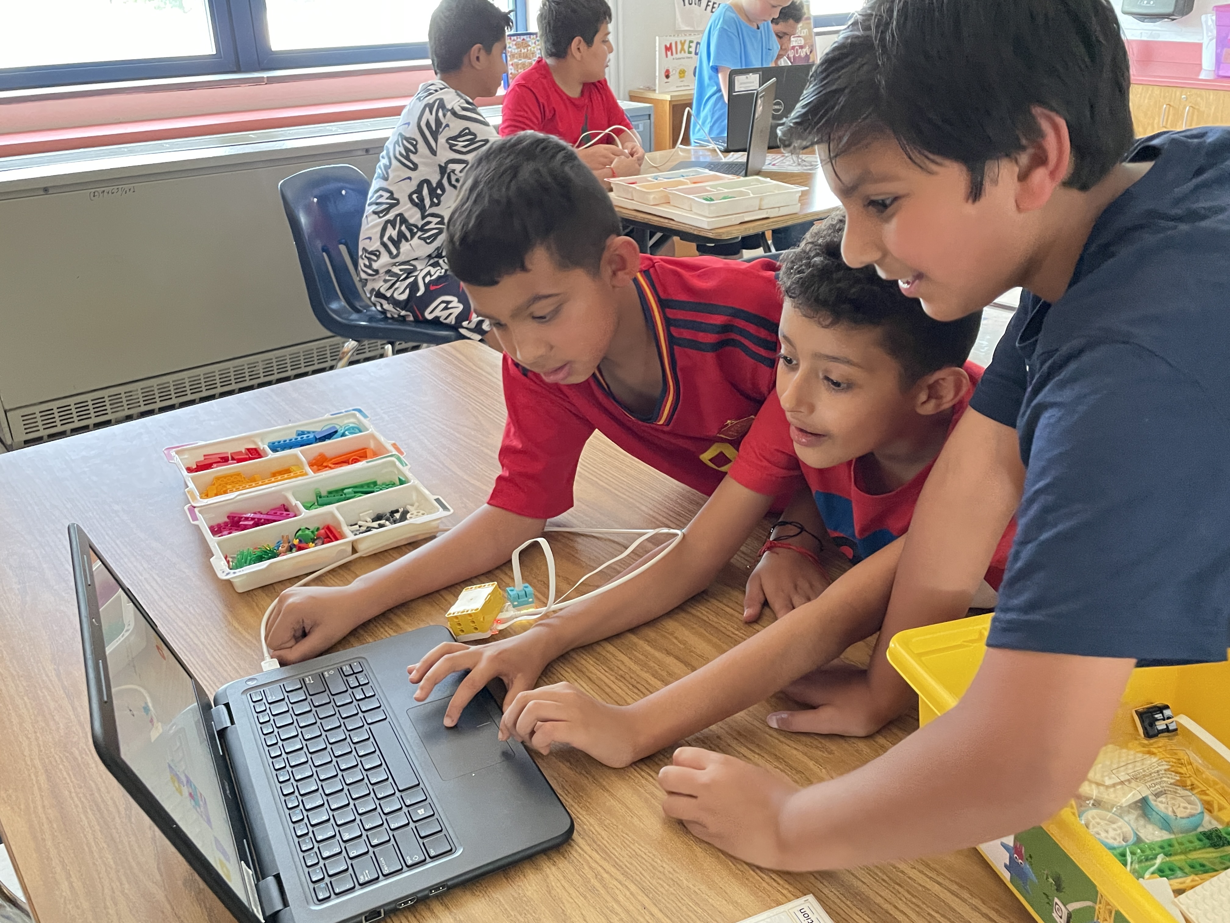 Three students using a computer during robotics class